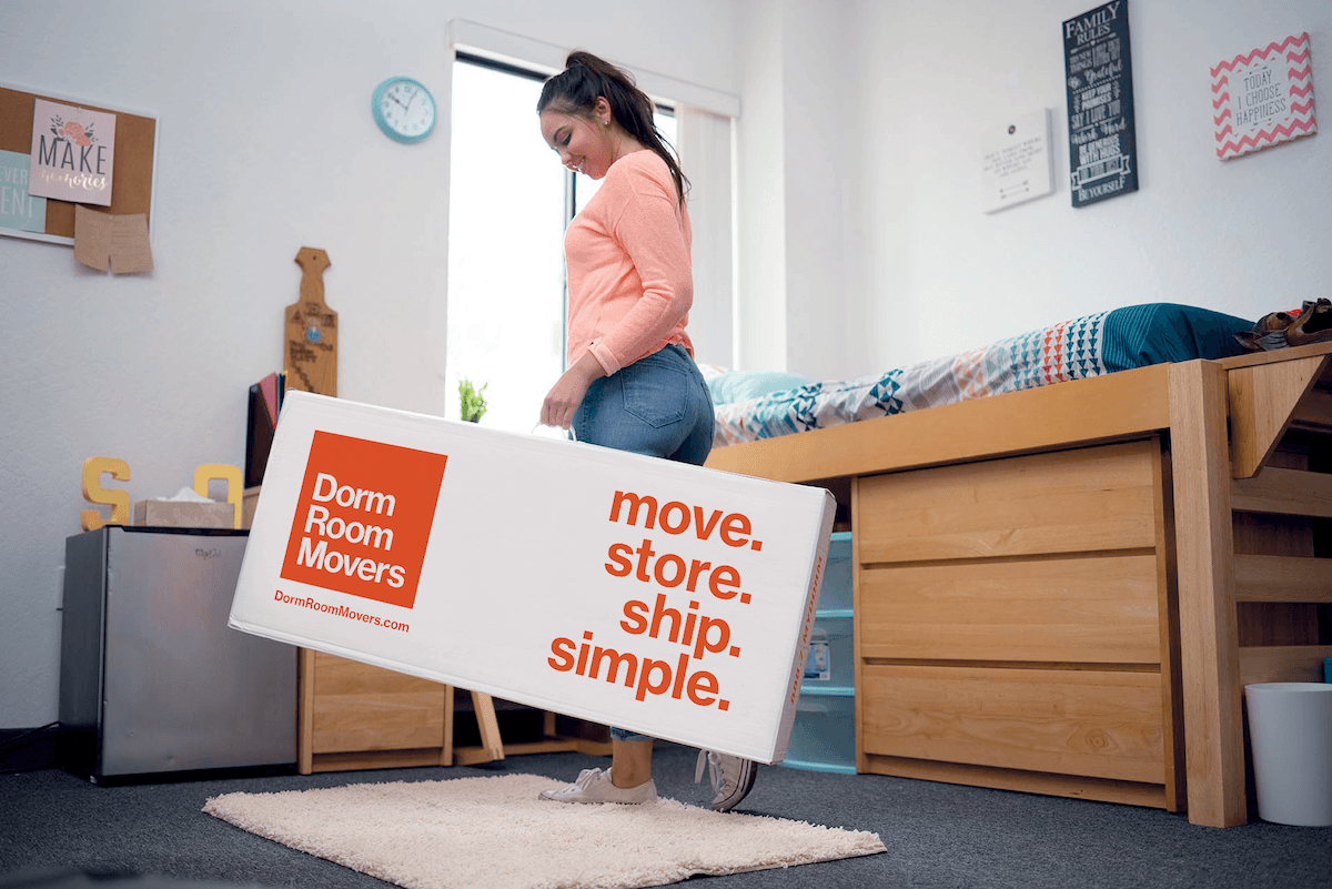 Student with Dorm Room Movers box in dorm room